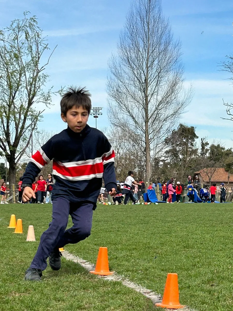 Alumno de Primary corre entre conos en el campo de deportes