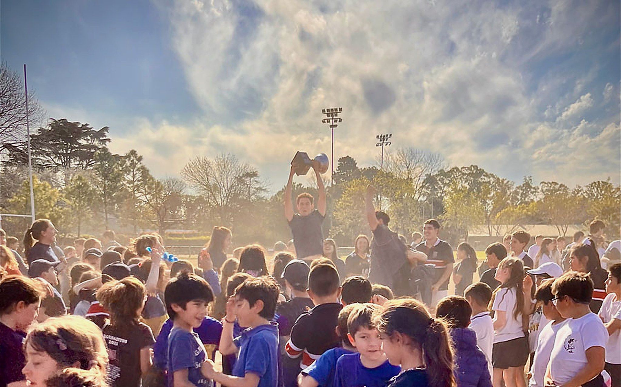 Jornada deportiva al atardecer: los alumnos celebran en el campo de deportes a contraluz