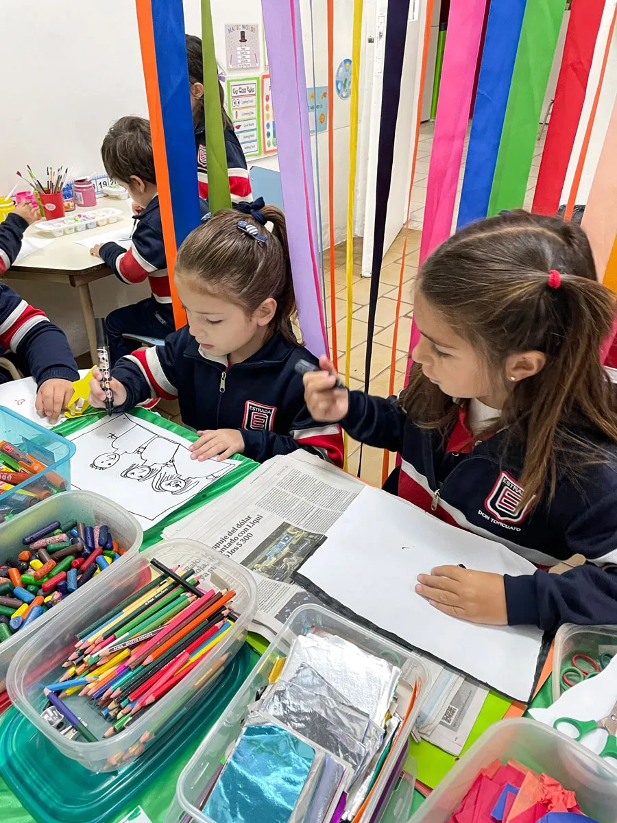 Dos nenas de Kinder dibujan juntas en la mesa de arte