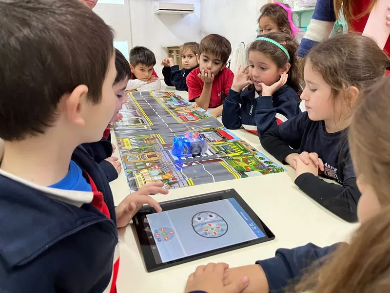 Chicos de Kinder programan un robot con una tablet en la sala