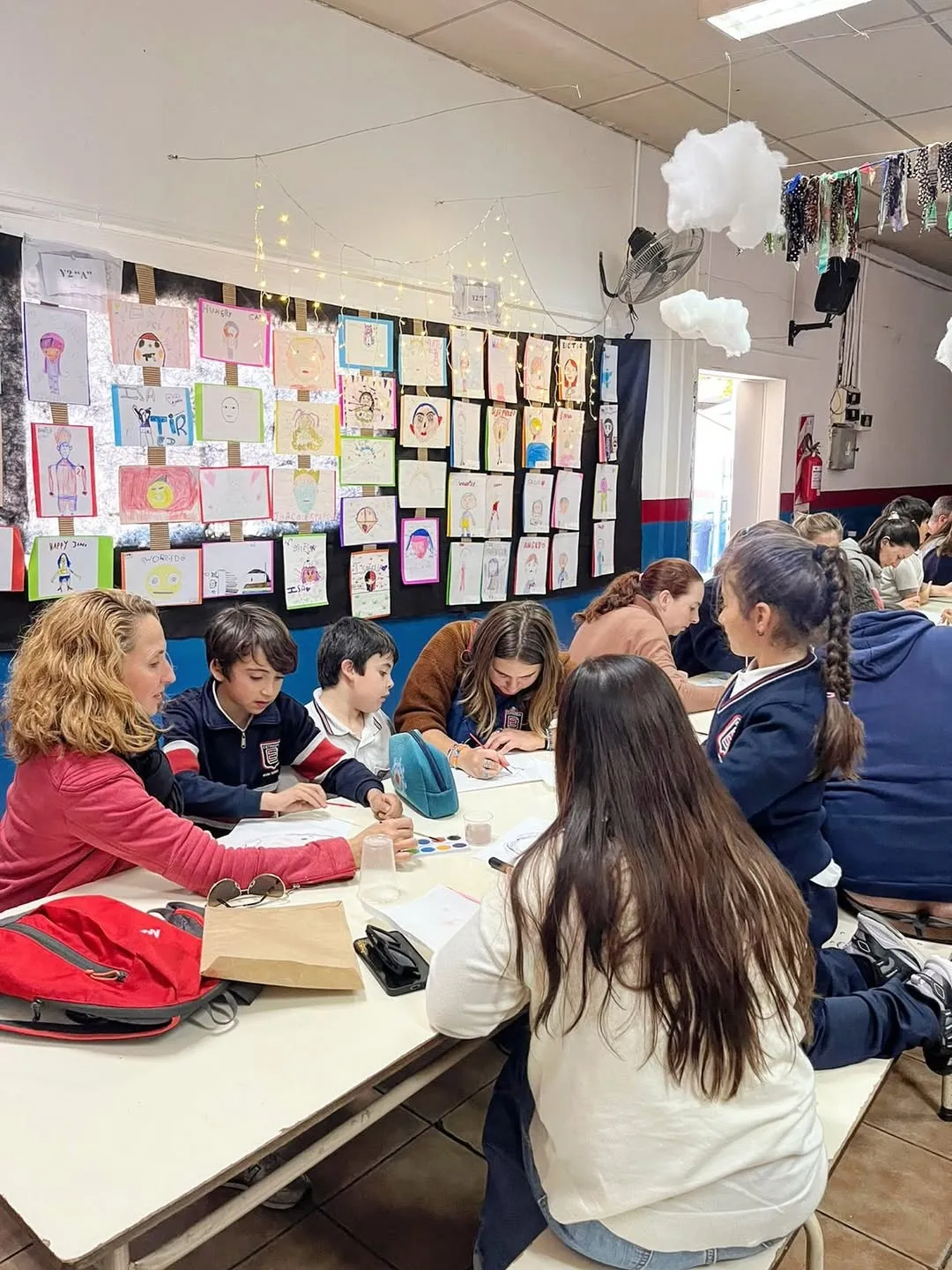 Alumnos y familias trabajando en un taller bilingüe, con producciones en las paredes